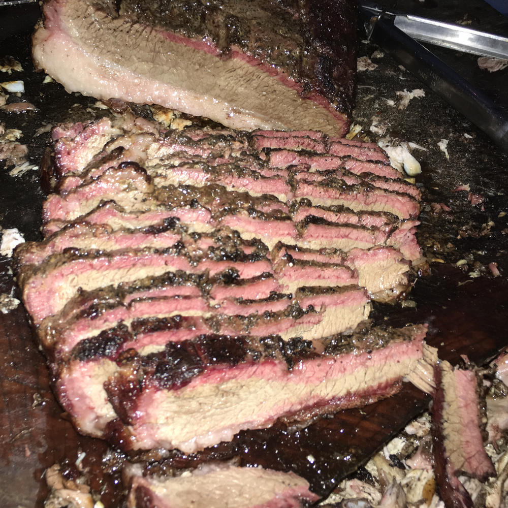 Sliced Texas-style beef brisket with a dark smoky bark and tender interior